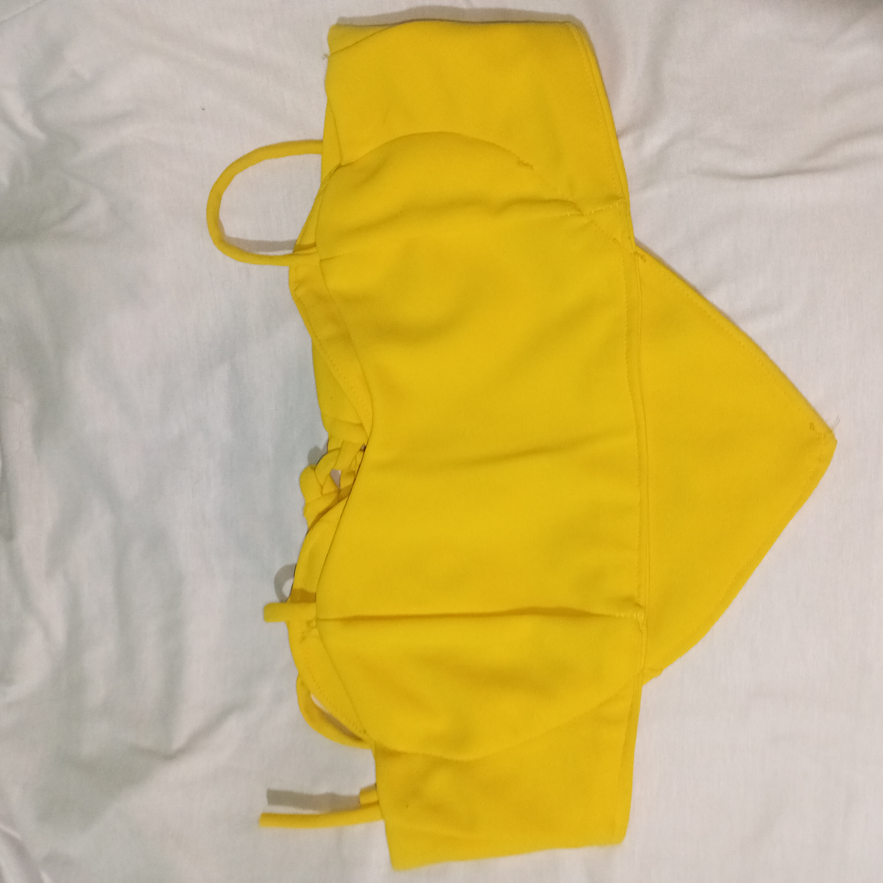 Usado poucas vezes ela tem amarração atrás e na frente ela é um formato de coração